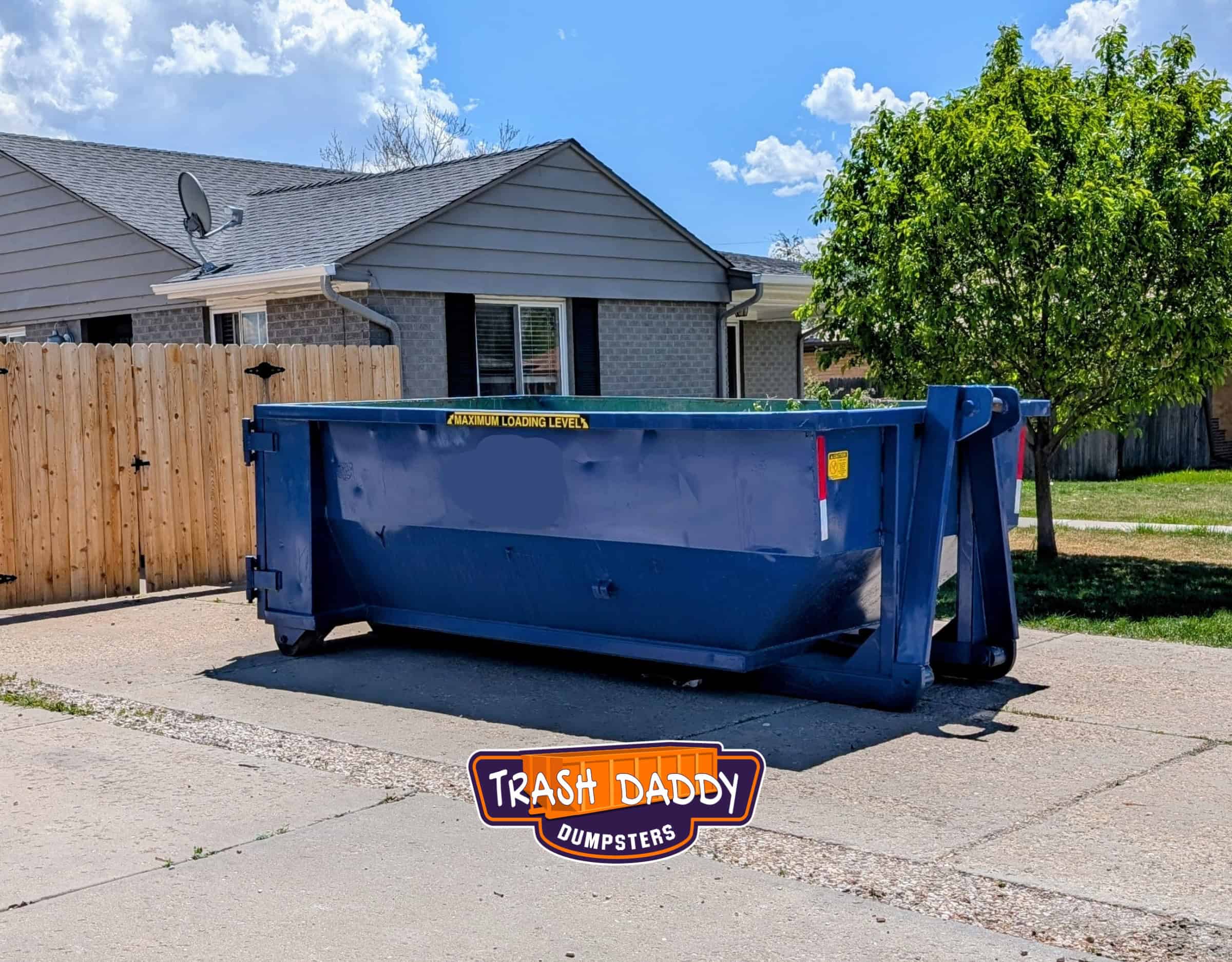 Blue 15 yard dumpster in a driveway.